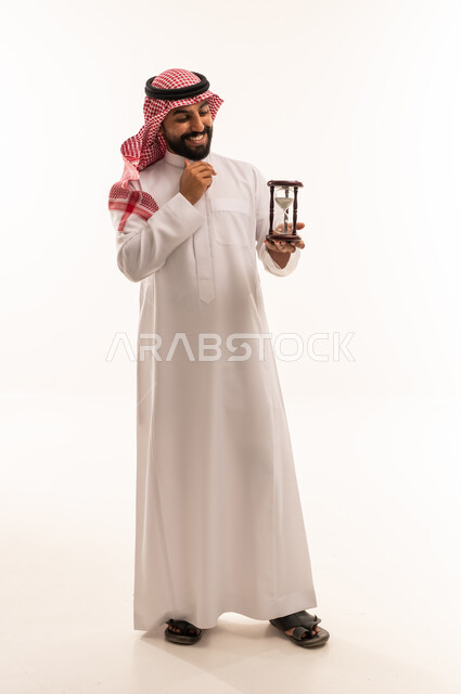 Saudi Man in Traditional Thobe Holding Hourglass