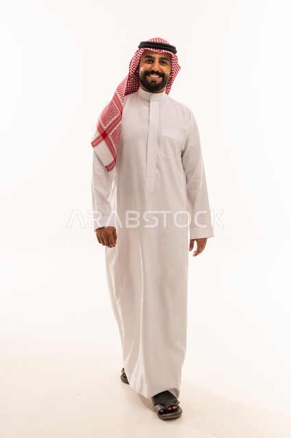 رجل سعودي بالزي التقليدي يمشي على خلفية بيضاء