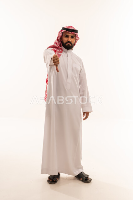 رجل سعودي بالزي التقليدي يشير بالإبهام للأسفل