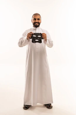 Saudi Man in White Thobe Holding Black Face Mask