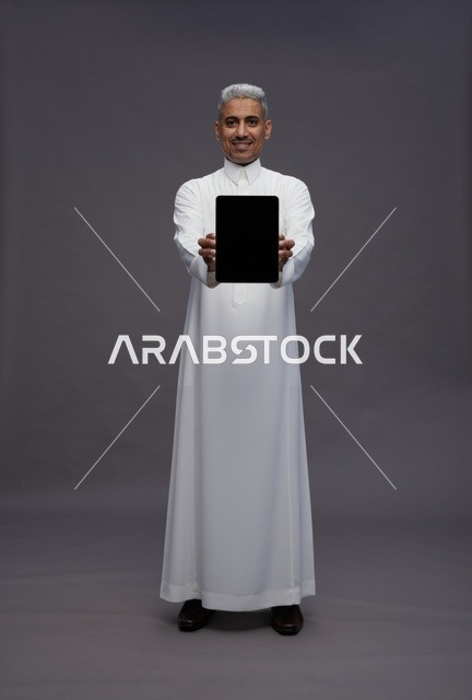 Saudi Man with Tablet on Gray Background