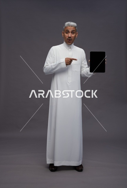 Saudi Man Pointing at Tablet Device on Grey Background