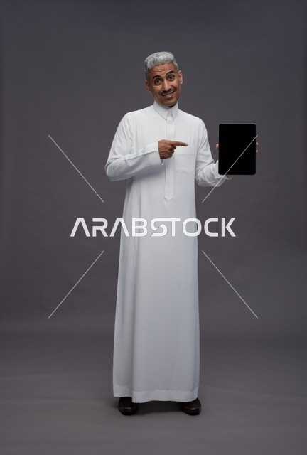 Saudi Man in Traditional Thobe Holding Digital Tablet
