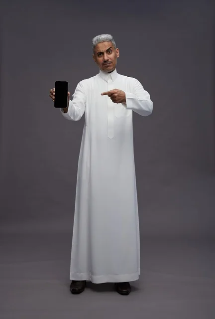 Saudi Man in Thobe Pointing at Smartphone Screen