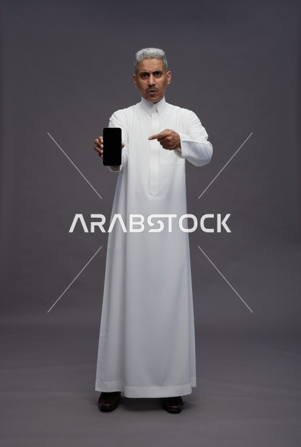 Saudi Man Pointing at Smartphone Screen in Studio