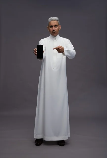 Saudi Man Pointing at Smartphone Screen in Studio