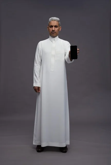 Saudi Man Holding Smartphone on Grey Background