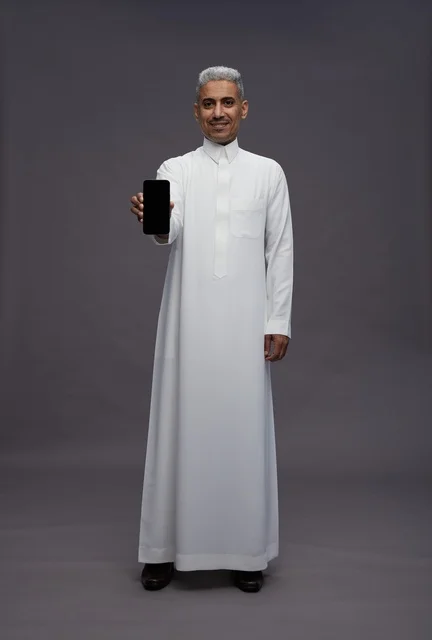 رجل سعودي يحمل هاتف ذكي بشاشة فارغة