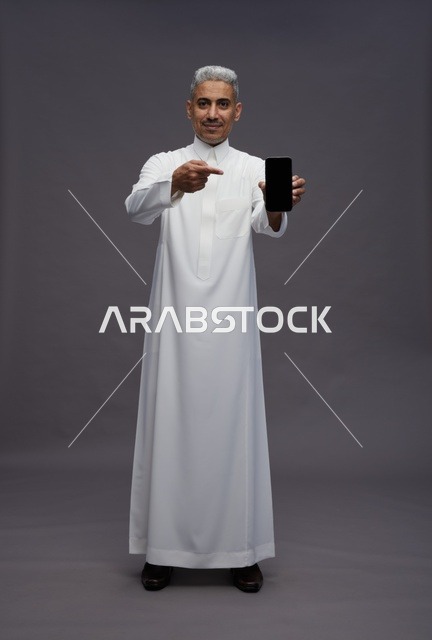 Saudi Man Holding Smartphone on Grey Background
