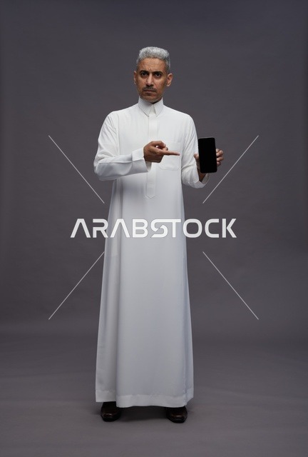 Saudi Man Pointing at Smartphone in Studio