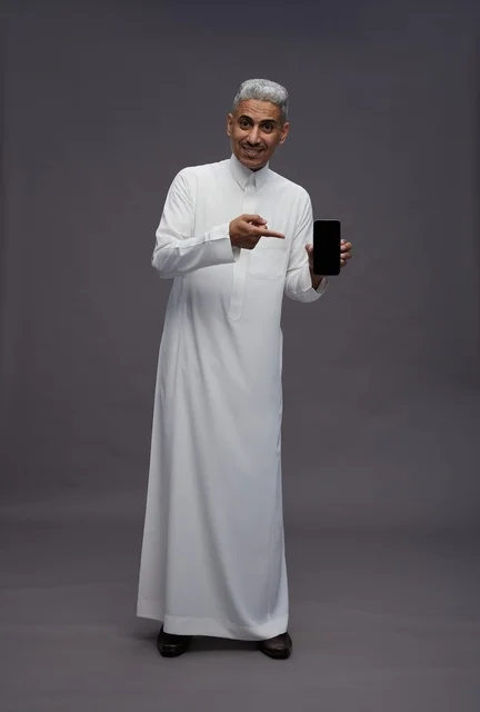 Saudi Man Holding Smartphone on Gray Background