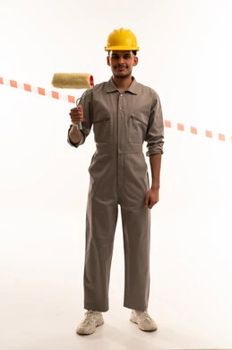 عامل بناء سعودي يحمل بكرة دهان ويرتدي خوذة