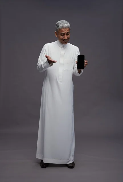 رجل سعودي يحمل هاتف ذكي في الاستوديو