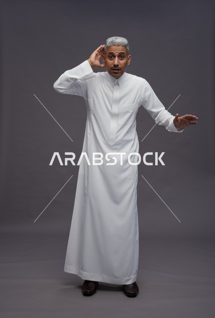 رجل سعودي يرتدي الثوب الأبيض بوضعية الاستماع في استوديو