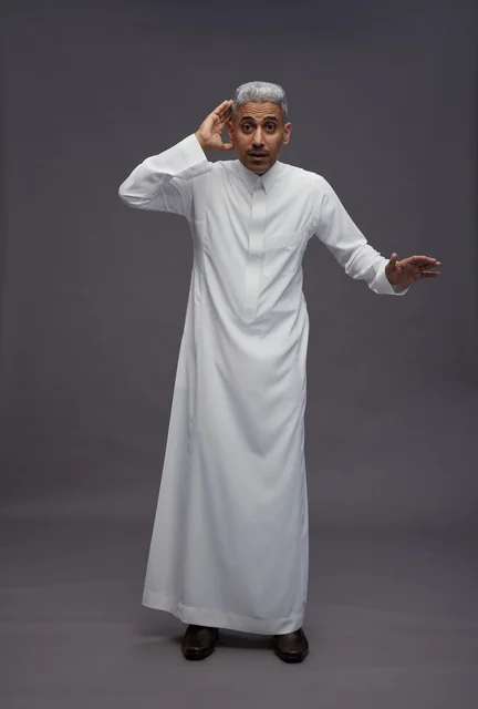 Saudi Man in White Thobe Listening on Grey Background
