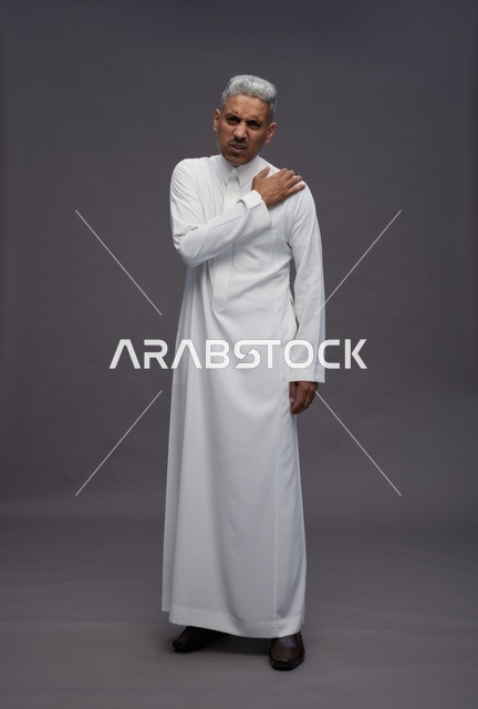 Saudi Man in White Thobe with Shoulder Pain in Studio