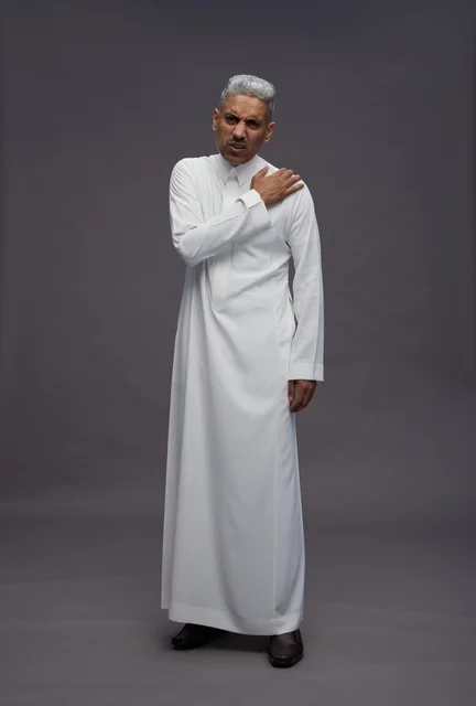 Saudi Man in White Thobe with Shoulder Pain in Studio