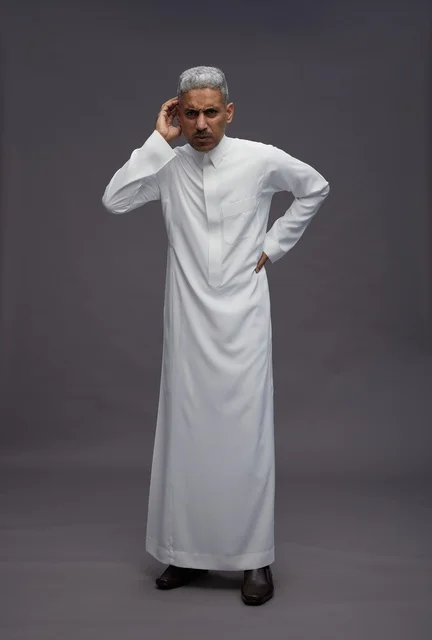 Saudi Man in White Thobe Listening on Gray Background