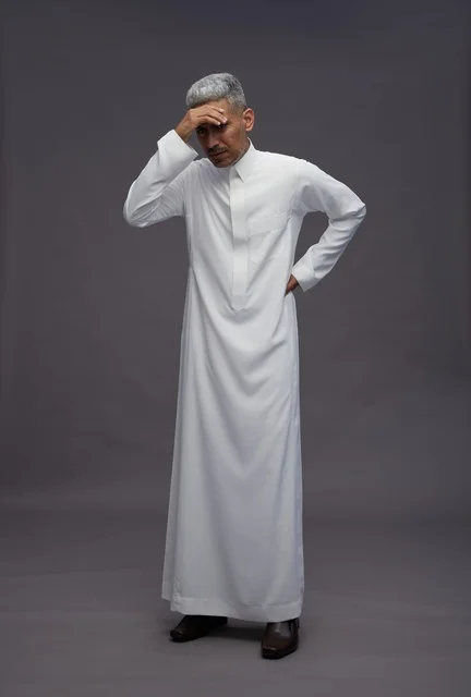 رجل سعودي بالثوب الأبيض يعبر عن القلق والتوتر