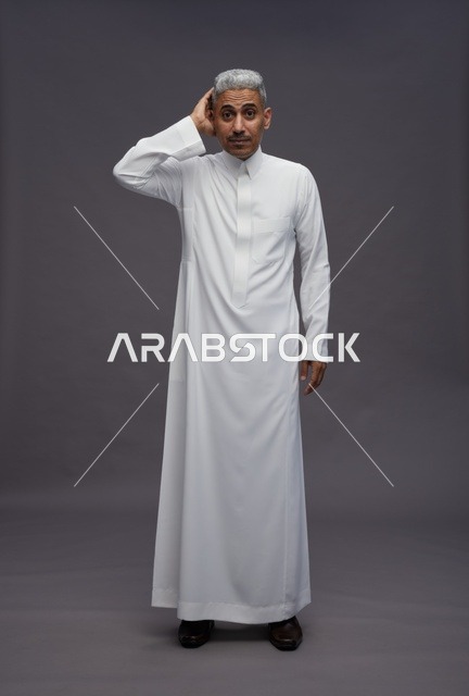 رجل سعودي بالثوب الأبيض بتعبير وجه يدل على الحيرة