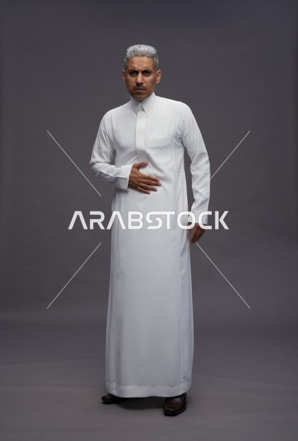 رجل سعودي بالثوب الأبيض يشعر بألم في المعدة