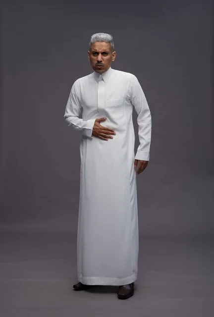 رجل سعودي بالثوب الأبيض يشعر بألم في البطن