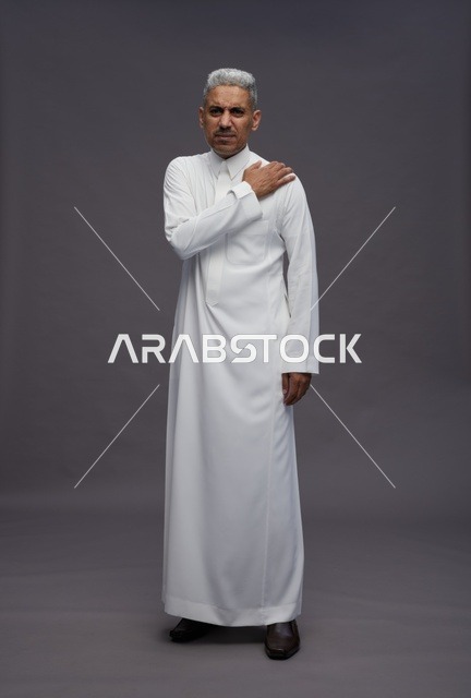 Saudi Man in Traditional White Thobe with Shoulder Pain