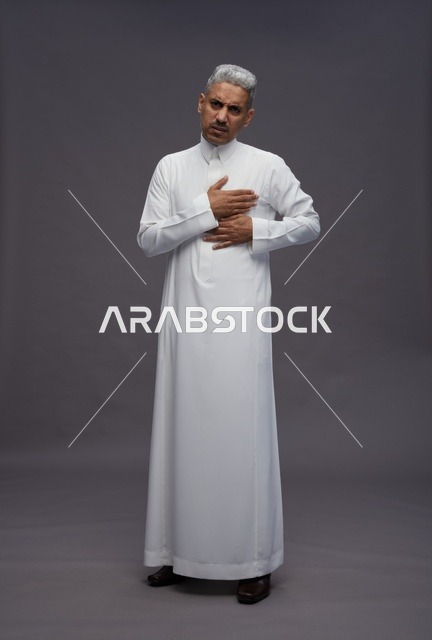 رجل سعودي بالثوب الأبيض يضع يده على صدره