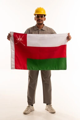 عامل بناء عماني ممسك بعلم سلطنة عمان