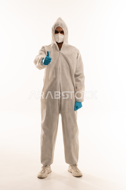 رجل عربي يرتدي بدلة وقاية مع إيماءة الإبهام