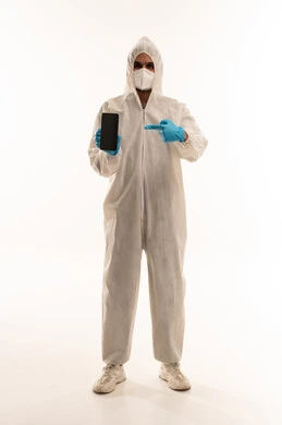 رجل سعودي ببدلة وقاية يشير إلى هاتف ذكي