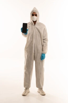 رجل سعودي يرتدي بدلة وقاية طبية ويحمل هاتف