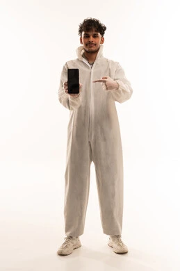 رجل عربي ببدلة وقاية يشير إلى هاتف ذكي