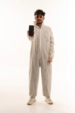 رجل سعودي ببدلة وقاية يمسك هاتف ذكي