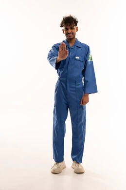 عامل سعودي بزي أزرق يقوم بإيماءة التوقف