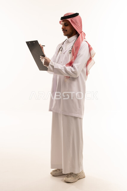 طبيب سعودي يكتب على لوحة ملاحظات خلفية بيضاء