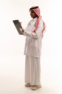 طبيب سعودي يكتب على لوحة ملاحظات خلفية بيضاء