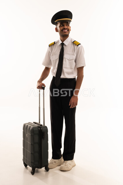 طيار سعودي بالزي الرسمي مع حقيبة سفر