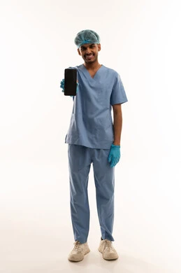 طبيب في زي العمليات الأزرق يحمل هاتفا ذكيا