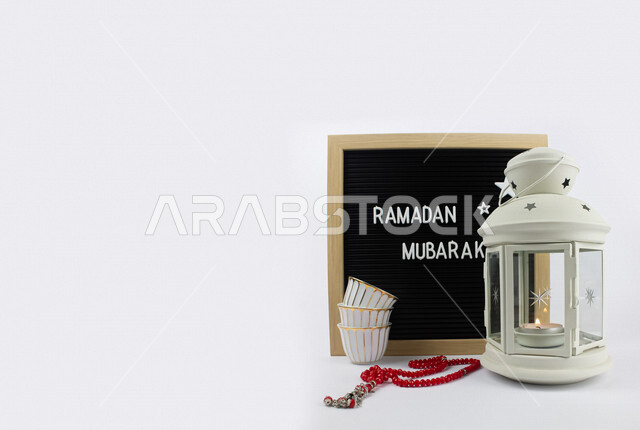 صورة لعبارة رمضان مبارك على لوح اسود ، فانوس رمضان ومسبحة حمراء ، مجموعة من فناجين القهوة ، الاستعداد لاستقبال رمضان ، اجواء رمضانية ، رمضان كريم