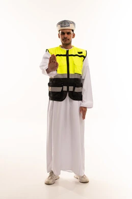 رجل عماني بزي السلامة يقوم بإيماءة التوقف