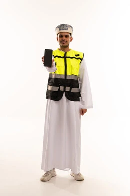 رجل عماني يرتدي سترة سلامة ويمسك هاتف ذكي