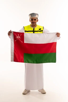 Omani Man Holding National Flag in Safety Vest