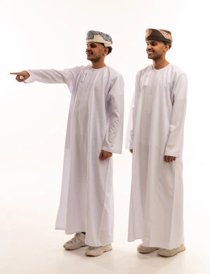 رجلان عمانيان بالزي التقليدي يشيران في استوديو أبيض