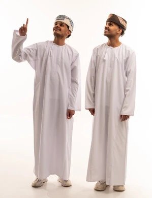 رجلان عُمانيان بالزي التقليدي يشيران للأعلى