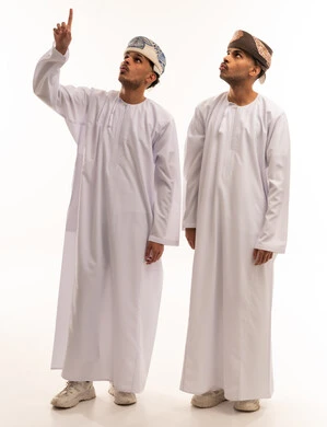 رجال عُمانيون بالزي التقليدي يشيرون للأعلى