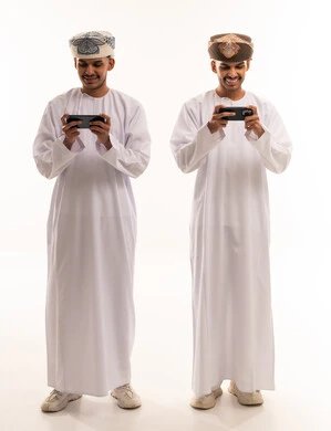Omani Men in Traditional Dress Using Smartphones
