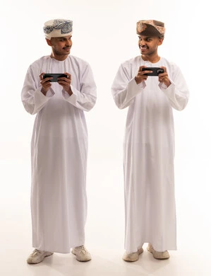 Omani Men in Traditional Dress Using Smartphones
