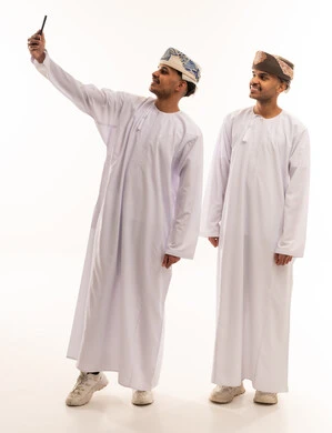 رجال عمانيون يلتقطون سيلفي بالزي العماني التقليدي