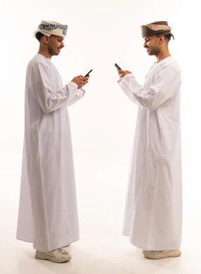 Omani Men Using Smartphones in Traditional Dress